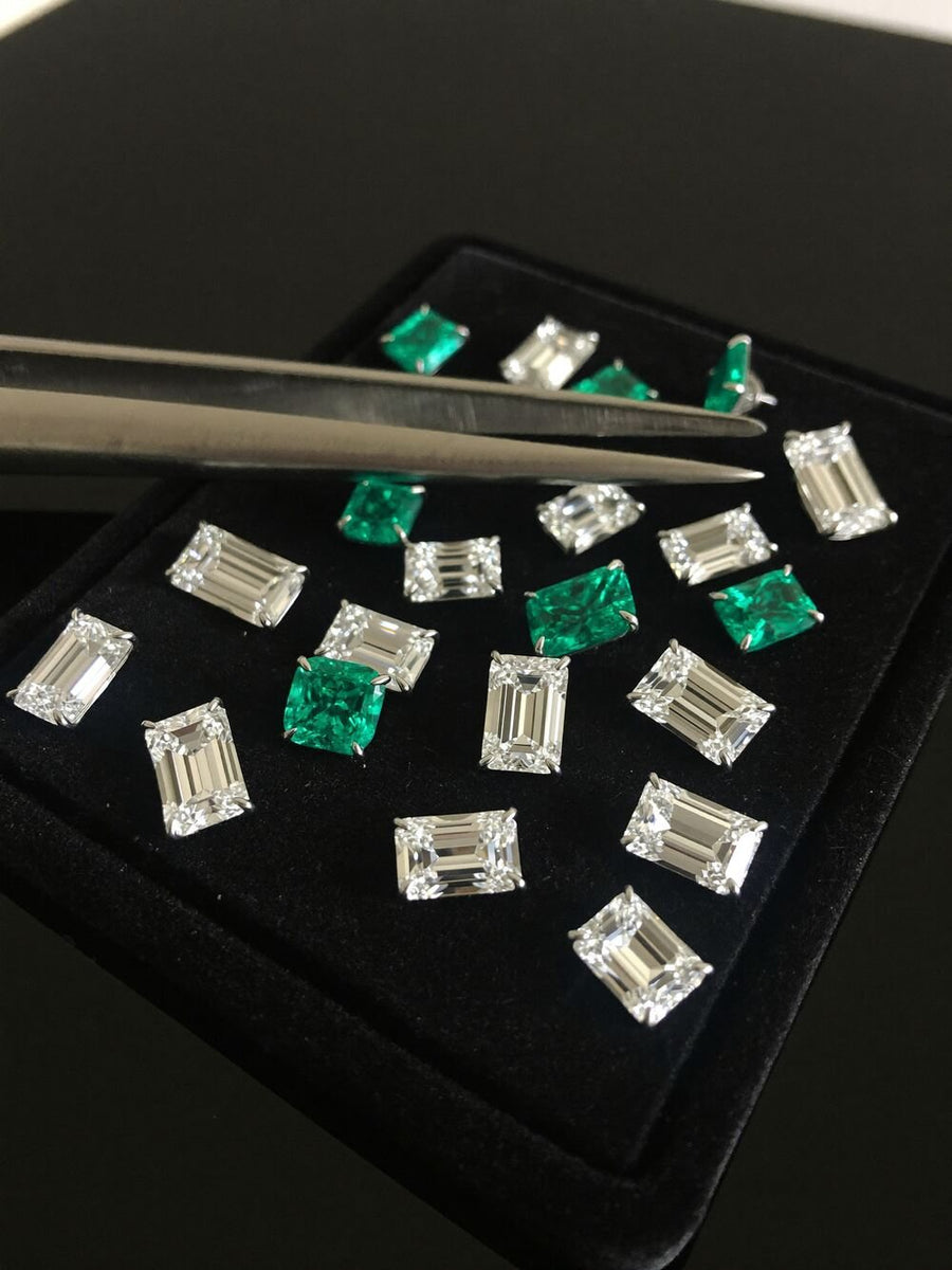 Emerald-cut stones on black velvet with tweezers